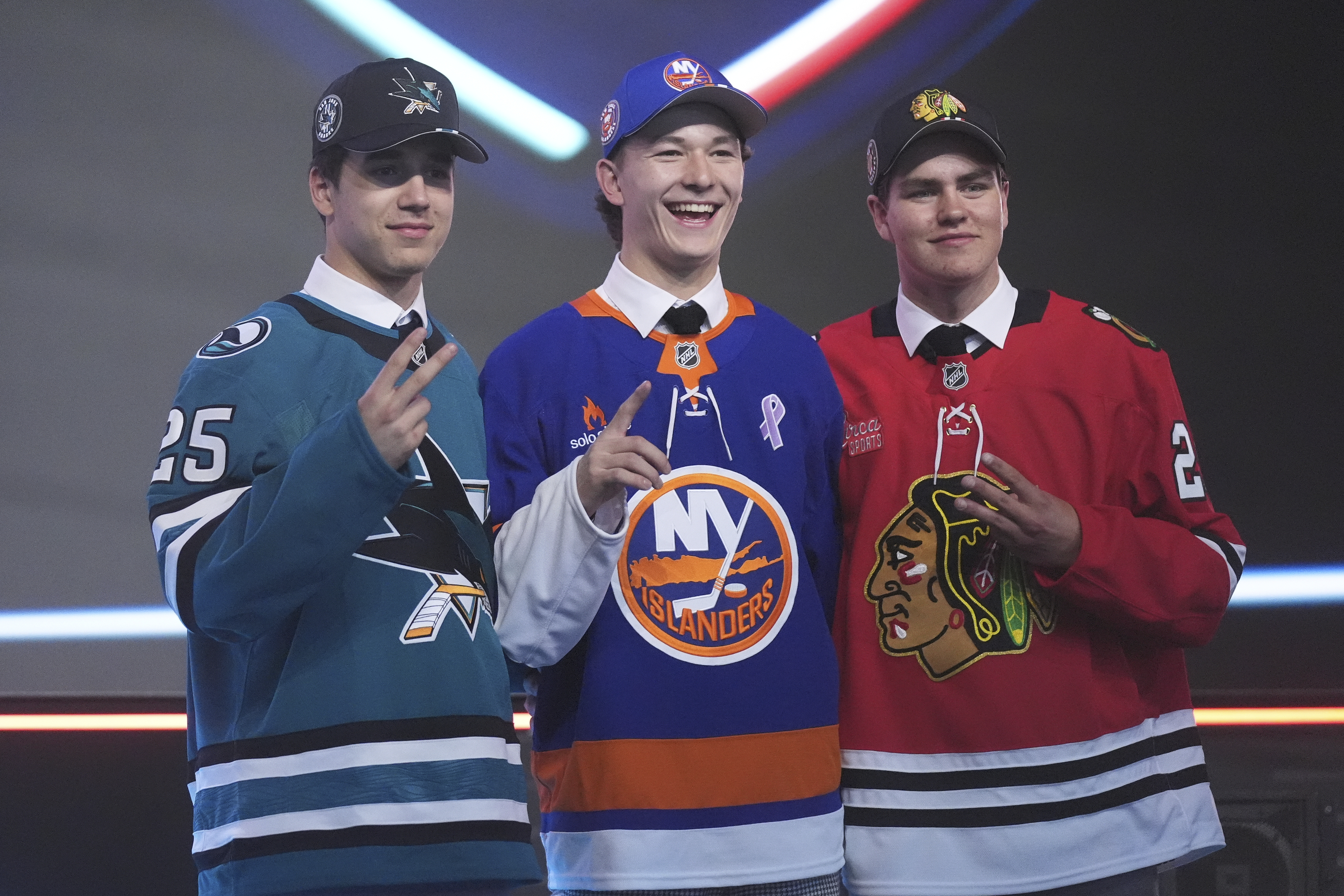 AP photo by Damian Dovarganes / Matthew Schaefer, drafted first by the New York Islanders, stands between Michael Misa, taken second by the San Jose Sharks, left, and Anton Frondell, picked third by the Chicago Blackhawks, on Friday night in Los Angeles.