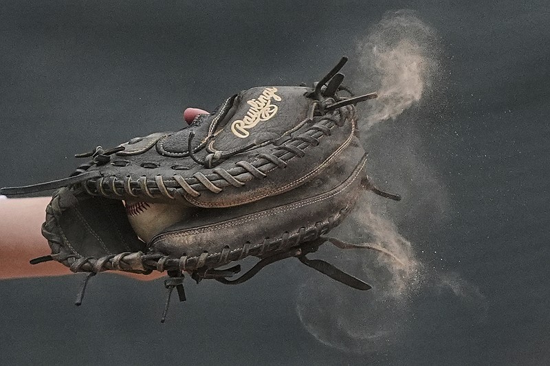 Dust flies from 15-year-old Jax Casamento's glove as he catches a pitch during a youth baseball game May 27, 2025, in Aston, Pa. (AP Photo/Matt Rourke)