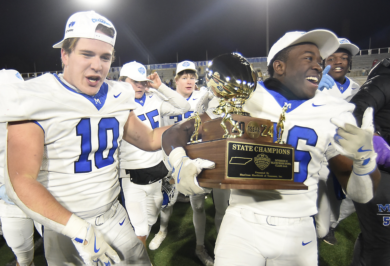 Staff photo by Matt Hamilton / McCallie's Philippe Robert (10) and Keylan Syam (26) celebrate together with the TSSAA Division II-AAA BlueCross Bowl state championship trophy at Finley Stadium on December 5, 2024.