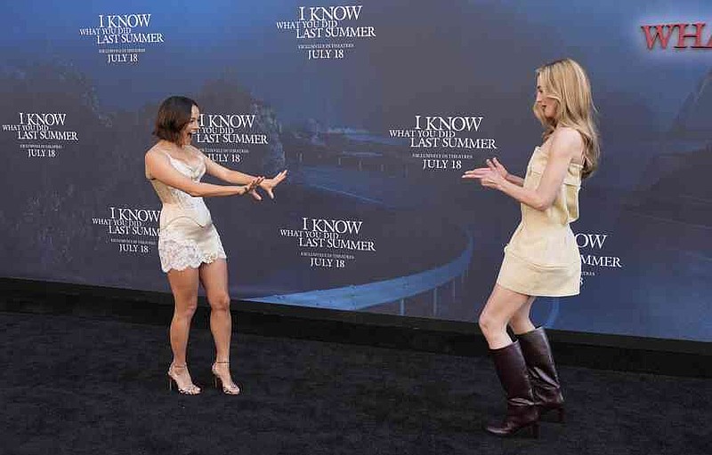Chase Sui Wonders, left, and Sarah Pidgeon, cast members in "I Know What You Did Last Summer," greet each other on the carpet at the premiere of the film at The United Theater on Broadway, Monday, July 14, 2025, in Los Angeles (AP Photo/Chris Pizzello)