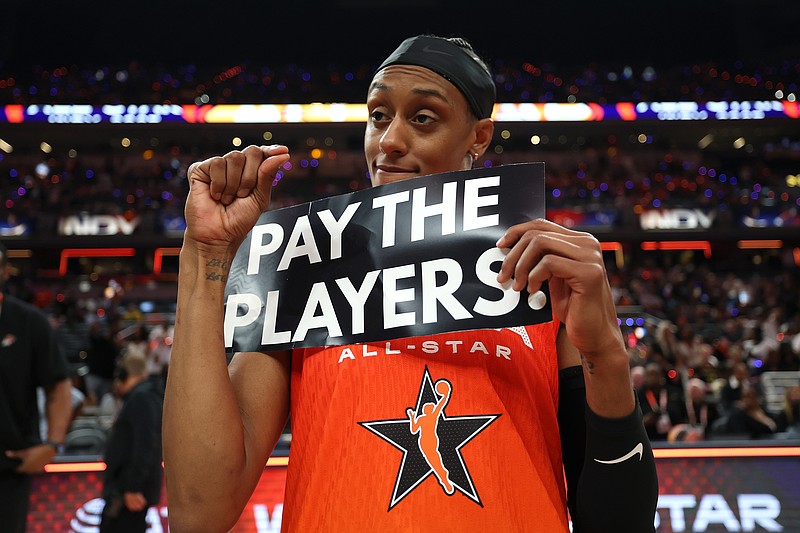 Brittney Sykes of the Washington Mystics holds a "Pay the Players" sign following the AT&T WNBA All-Star Game at Gainbridge Fieldhouse on Saturday, July 19, 2025, in Indianapolis. (Steph Chambers/Getty Images/TNS)