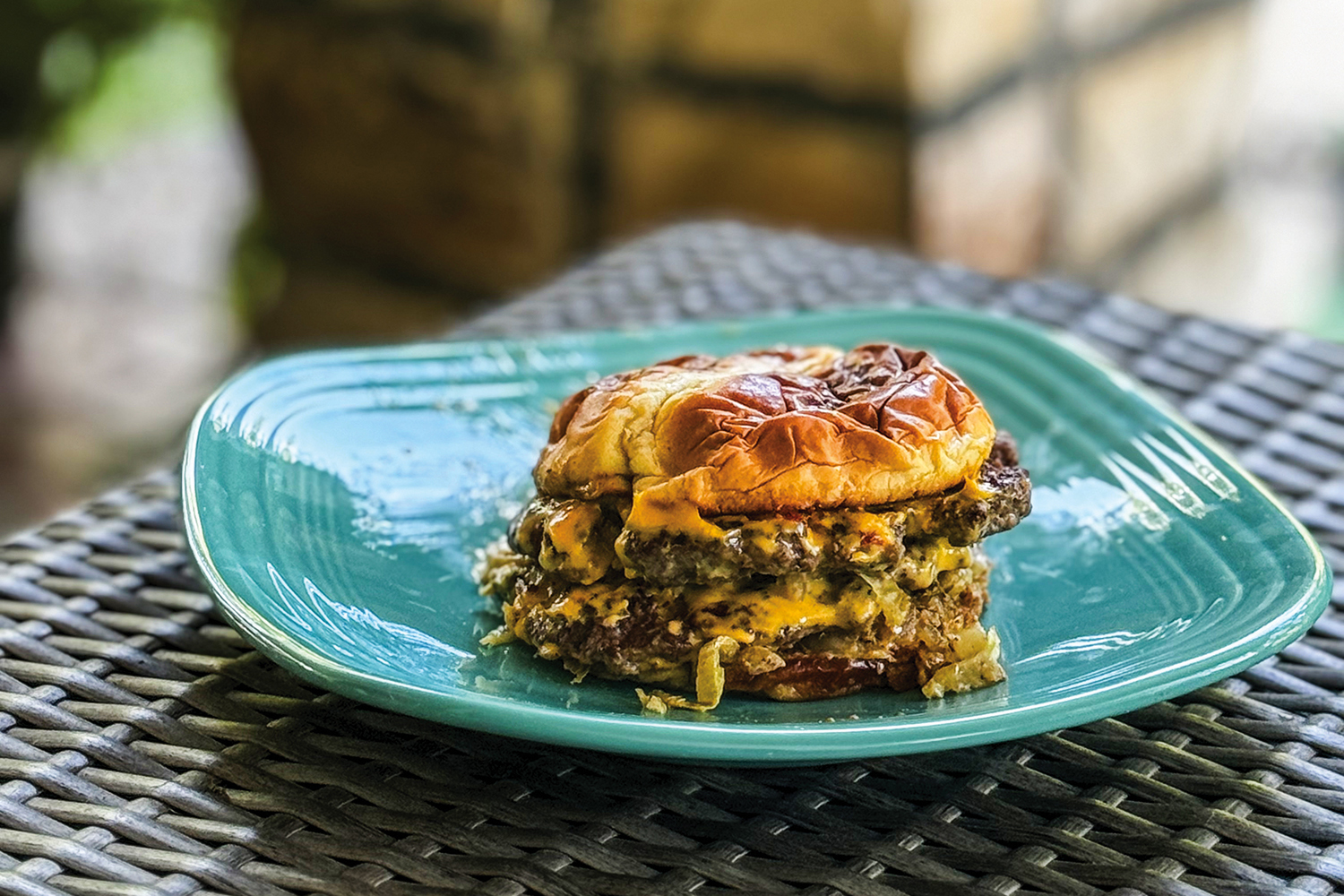 Photo by Lisa Denton / Lo Main's signature Murder Burger features two smashed beef patties on a brioche bun. Having two patties — about the size of a standard patty when combined — doubles the surface for the addition of American cheese, caramelized onions, lettuce and garam masala mayonnaise.