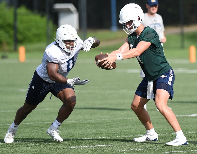Staff photo by Matt Hamilton / UTC quarterback Luke Schomburg fakes a handoff to Ryan Ingram during a preseason practice on July 31 at Scrappy Moore Field.