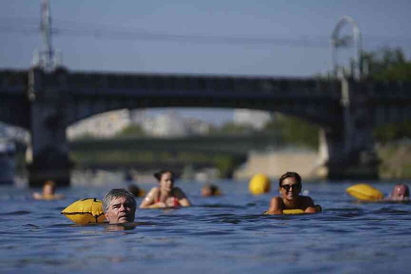 People swim in the Seine river, Monday, Aug. 11, 2025 in Paris. (AP Photo/Aurelien Morissard)