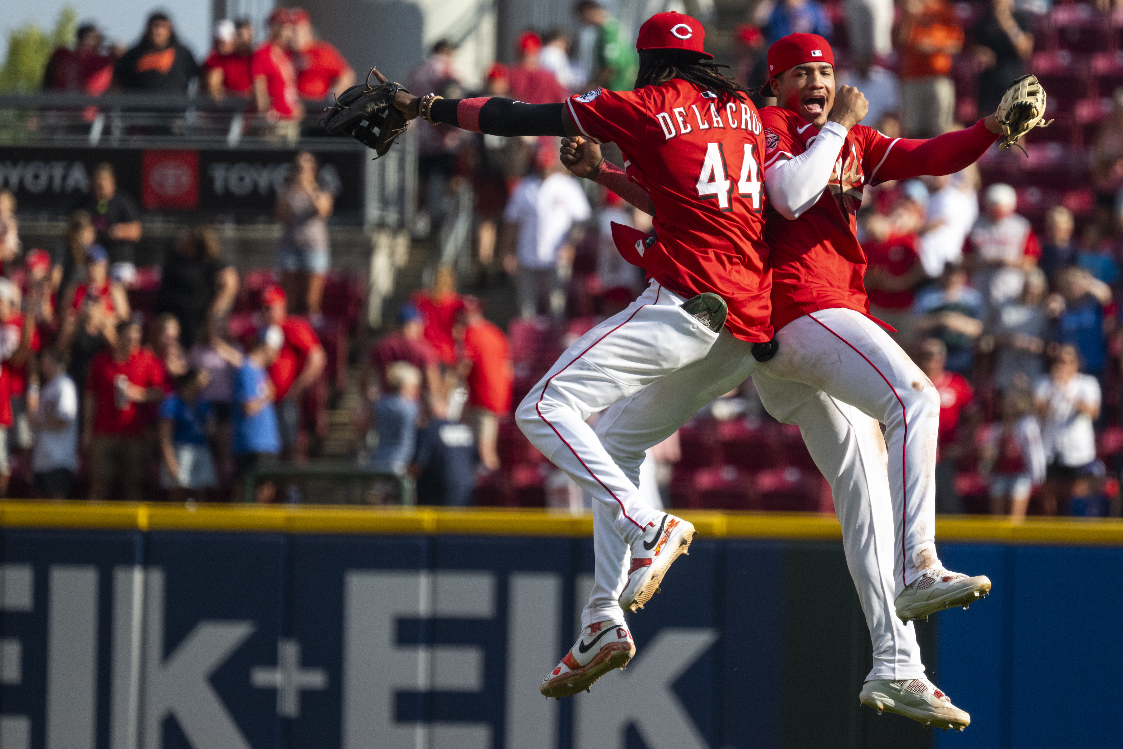 Cincinnati Reds shortstop Elly De La Cruz (44) and outfielder Noelvi Marte (16) bump shoulders after defeating the Chicago Cubs, Sunday, Sept. 21, 2025, in Cincinnati. (AP Photo/Michael Swensen)
