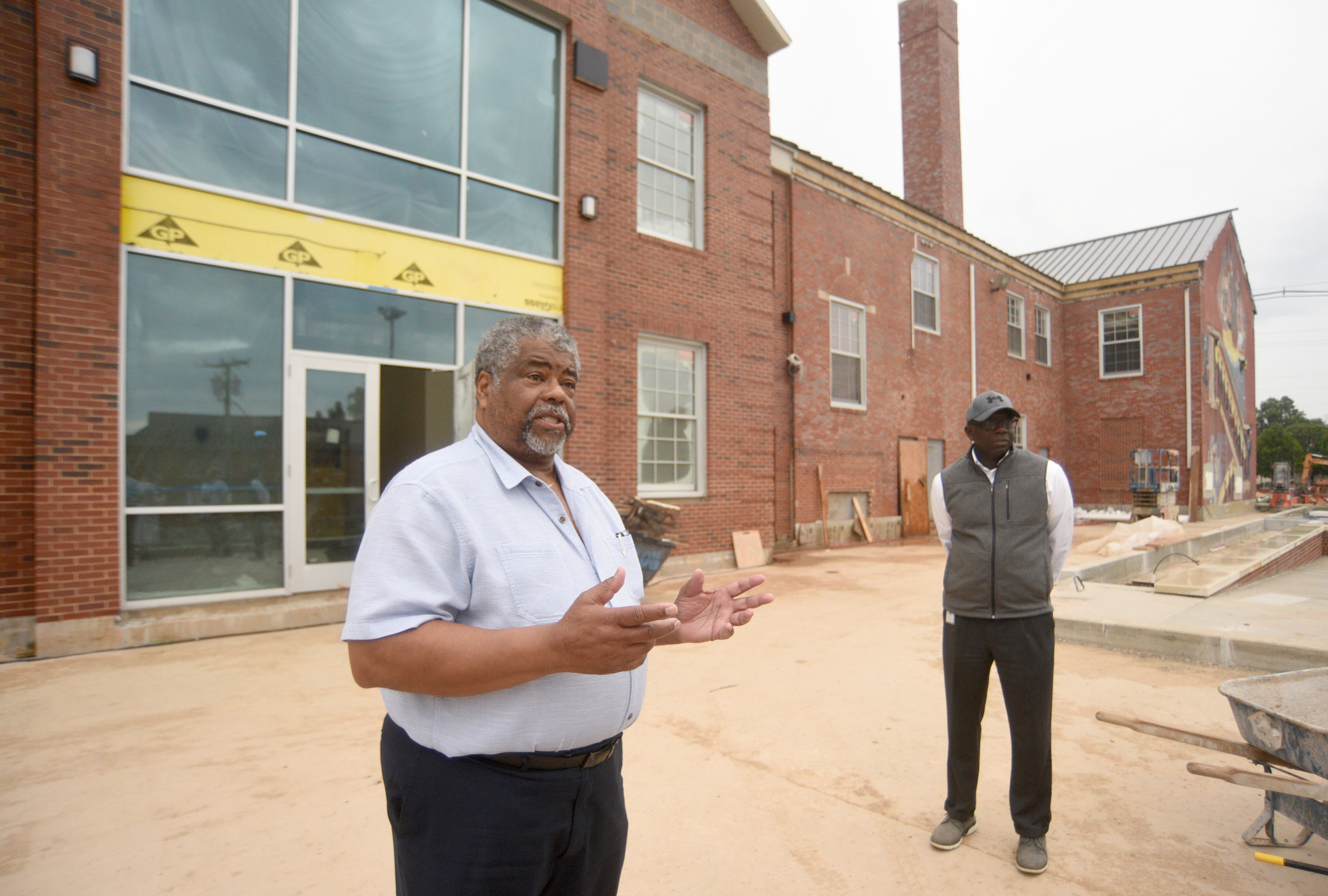 Staff photo by Matt Hamilton / Project manager Anthony Fears, back, looks on Sept. 23, 2025, as architect Reginald Ruff speaks during a tour of the James A. Henry building.