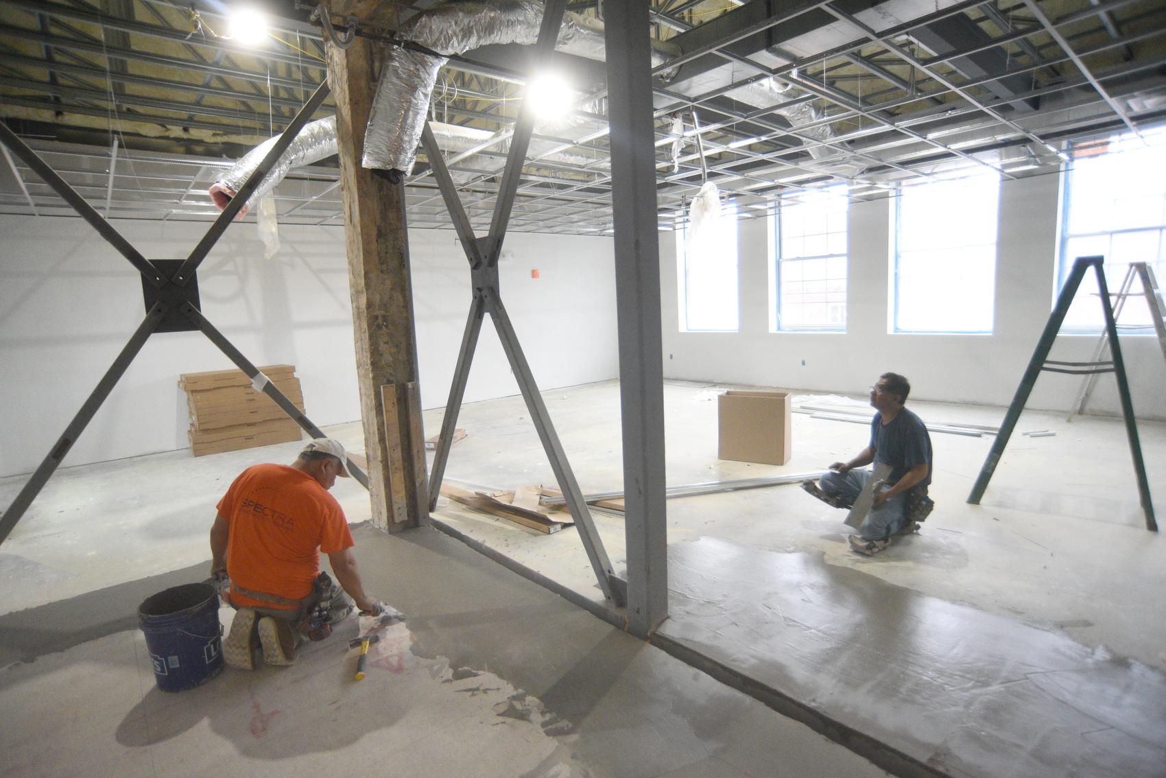 Staff photo by Matt Hamilton / Workers lay down concrete on the floor of a room Sept. 23, 2025, in the James A. Henry building.