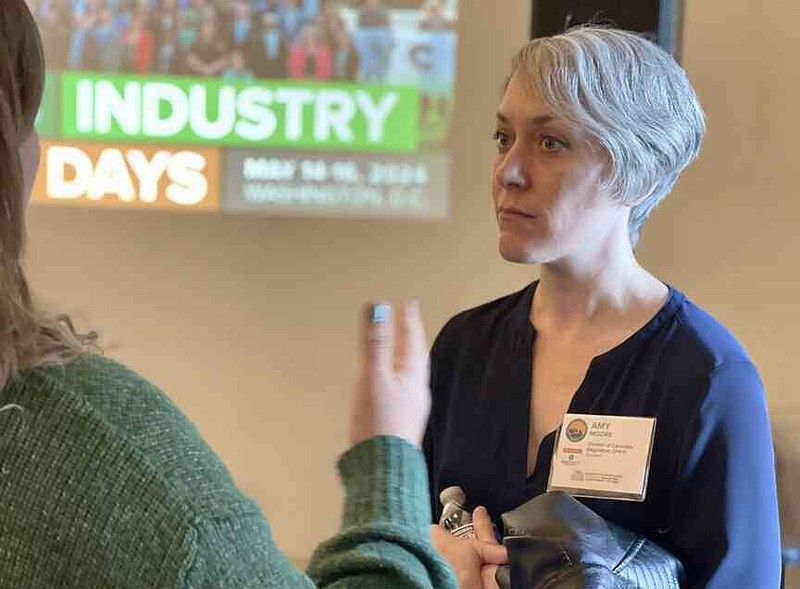 Rebecca Rivas/Missouri Independent Amy Moore, director of the Missouri Division of Cannabis Regulation, speaks with a microbusiness owner at the National Cannabis Industry Association's summit in St. Louis in 2024.