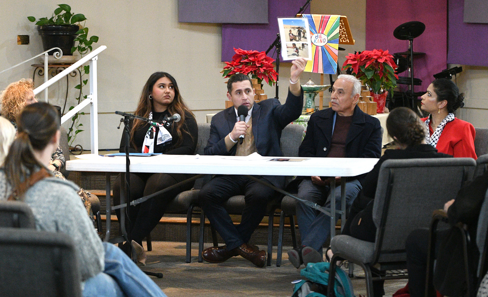 Staff Photo by Robin Rudd / Anthony Aguilar, former Army officer and contractor with the Gaza Humanitarian Foundation, holds up a photo of an 8-year old boy named Amir, who Aguilar said was killed by the Israeli Defense Force. Aguilar spoke at a Human Rights Day event at the Unitarian Universalist Church.
