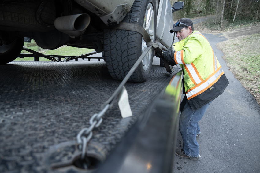 Staff Photo by Seth Carpenter / David Clark, a driver for Shackleford Towing & Recovery, secures ratchet straps to a pickup truck in St. Elmo.