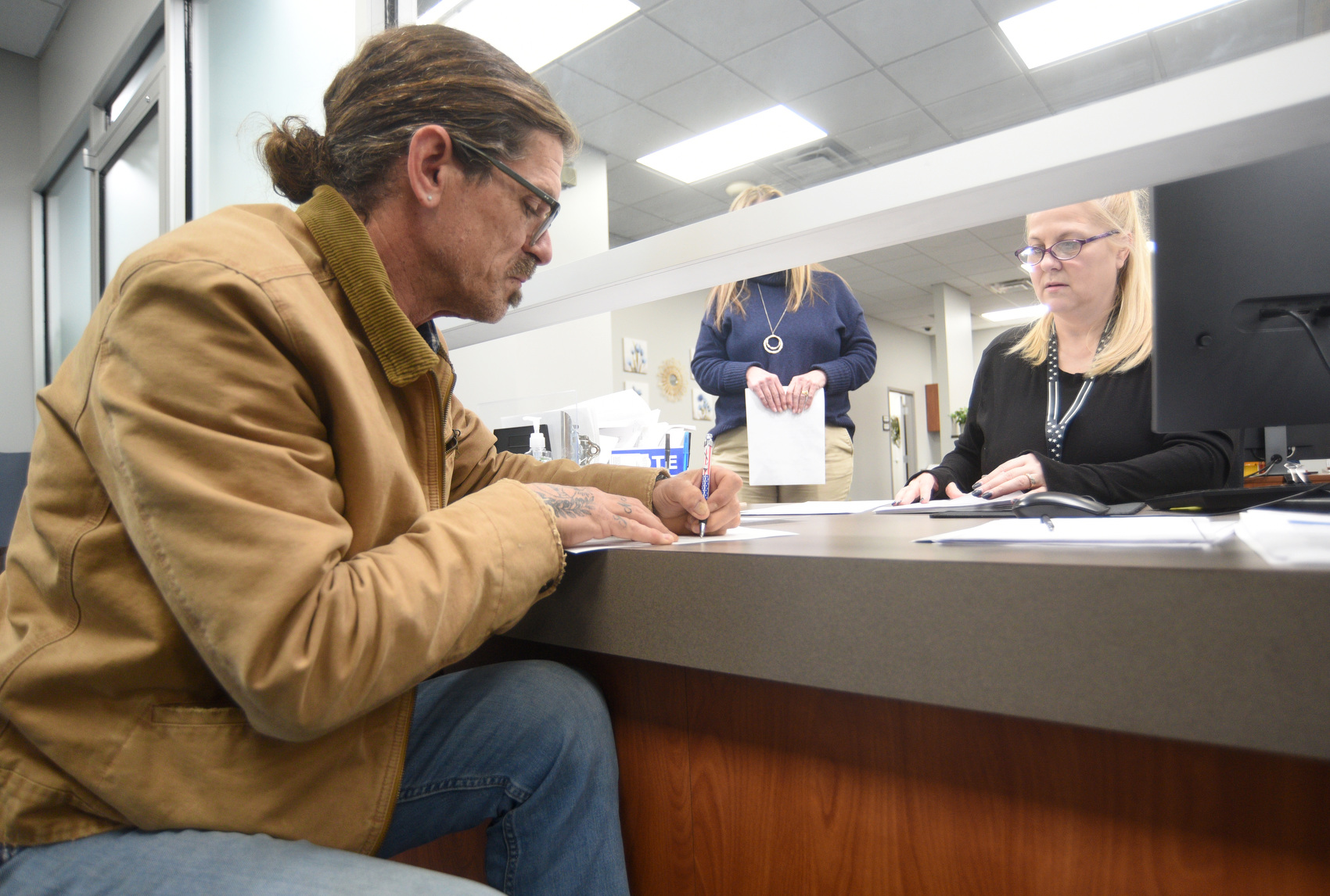 Staff photo by Matt Hamilton / Debbie Lawrence with the Hamilton County Elections Office looks on as Mark Herndon, a Democratic challenger for county mayor, fills out paperwork.