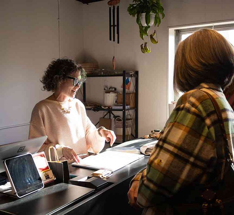 Sophie Ayers/News Tribune Andii Kreek Irwin, left, talks to customers on Thursday during the She's Native Social.