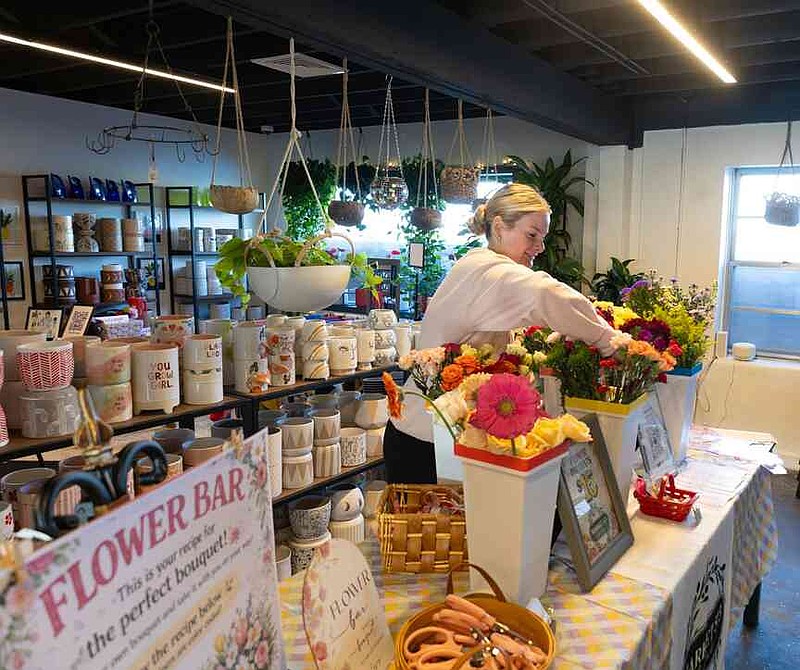 Sophie Ayers/News Tribune Lexy Messerly adjusts a flower at the popup Flower Bar on Thursday during the She's Native Social.