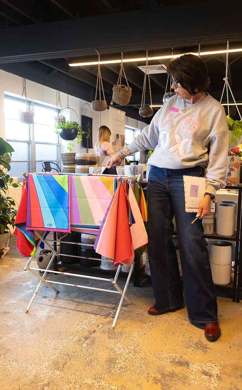 Sophie Ayers/News Tribune Tanya Rhine, a color analysis coach, shows off different prints of color patterns on Thursday during the She's Native Social.