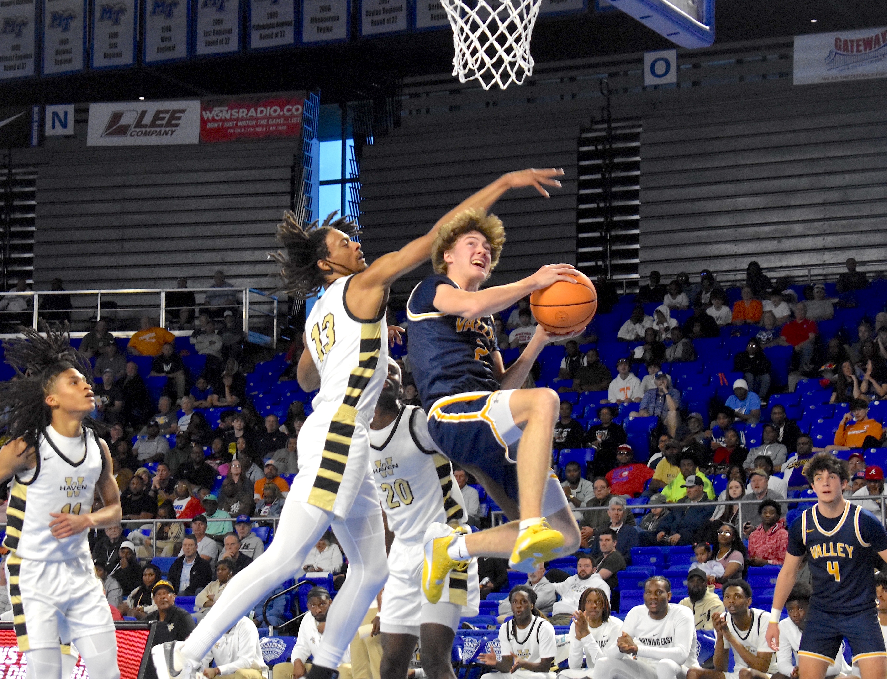 Staff photo by Patrick MacCoon / Walker Valley senior Turner Clayton finishes a tough layup underneath a Whitehaven defender during a TSSAA Class 4A state semifinal Friday at Middle Tennessee State University's Murphy Center.
