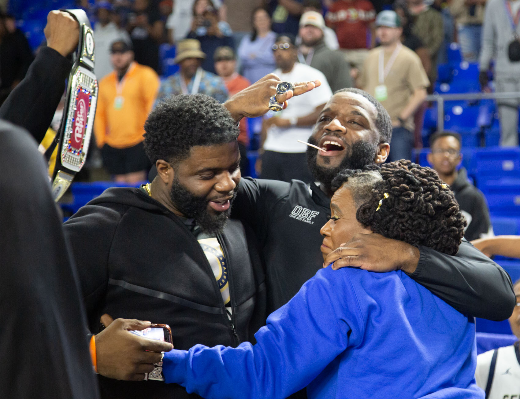 Staff photo by Larry Sullivan II/Chatt. Prep boys basketball Head Coach Christian Collins(middle) holds up his championship rings while being embraced after winning the Class 2A basketball state championship game on Saturday, March 21, 2026.