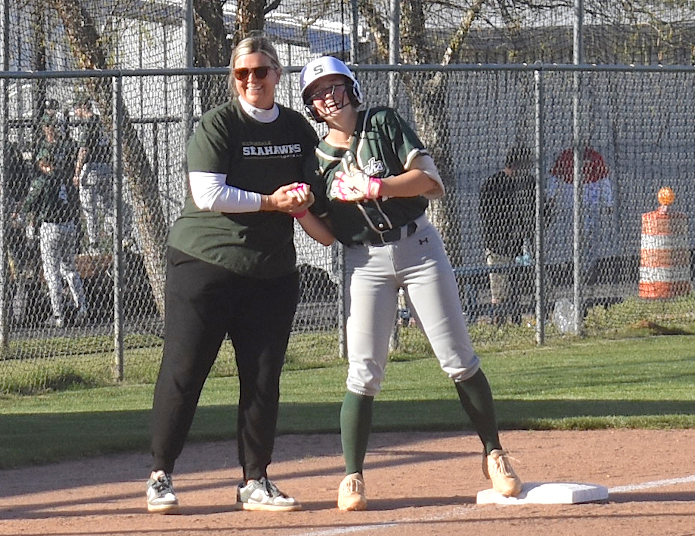 Staff photo by Patrick MacCoon / Silverdale Baptist head coach Jackie Freelend laughs with junior star Bita Cox on third base during a 12-2 road victory over Chattanooga Christian on Monday.