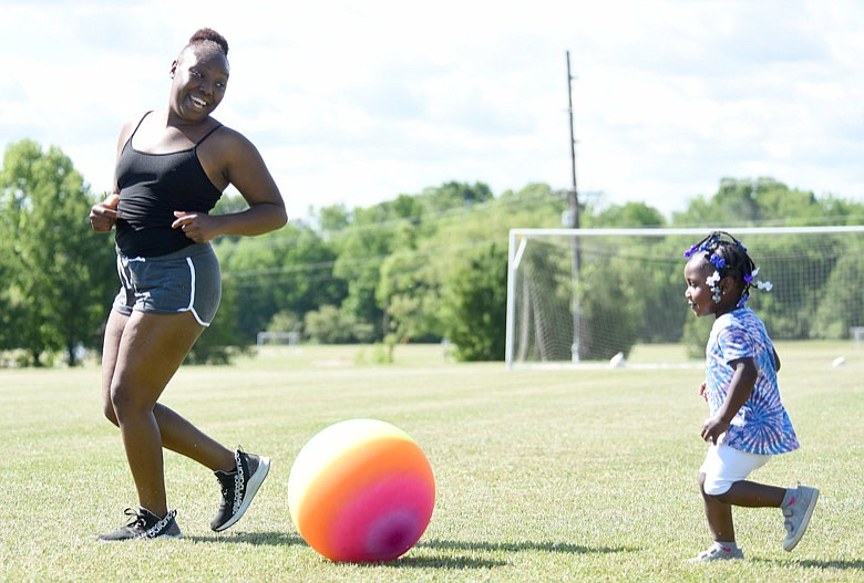 Staff Photo by Matt Hamilton / East Ridge resident Paisley Smith, 2, kicks a large rainbow-colored ball with her mother Katreia Toran at Camp Jordan on Friday, May 13, 2022. The two enjoyed the pleasant weather while kicking the ball for a while before moving on to the playground.