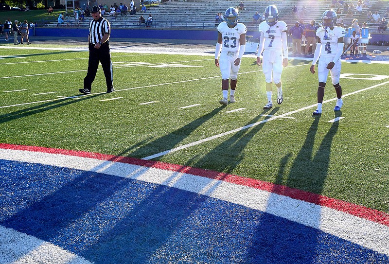 Staff Photo by Robin Rudd / The Red Bank captains cast long shadows as they approach midfield for the coin toss.   The Red Bank Lions visited the Cleveland Blue Raiders, in TSSAA football action, on Thursday night, August 19, 2022.