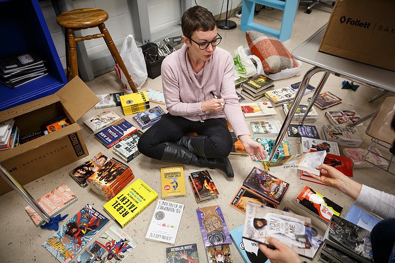 Staff photo by Doug Strickland / 
English teacher Katelyn Dix sorts through donated books in her classroom at Howard School on Saturday, Dec. 8, 2018, in Chattanooga, Tenn. Dix's classroom is the first to receive a donation of books and furnished reading nooks from the activist organization Moms for Social Justice's Classroom Library Project.