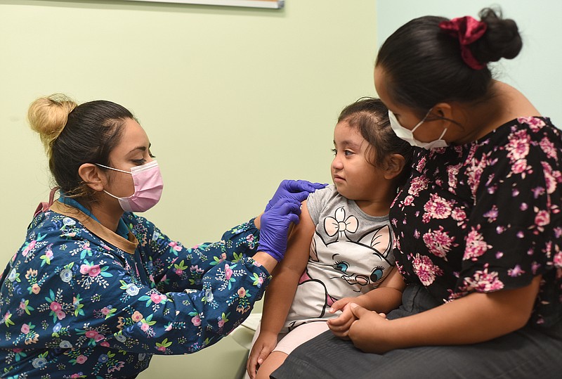 Staff photo by Matt Hamilton / Medical assistant Brenda Resendiz, left, cleans the injection site on the arm of Alexa Raymundo, 4, as her mom, Elizabeth Pedro Raymundo, of Hixson, comforts her before her vaccinations at LifeSpring Community Health on Friday, August 19, 2022.