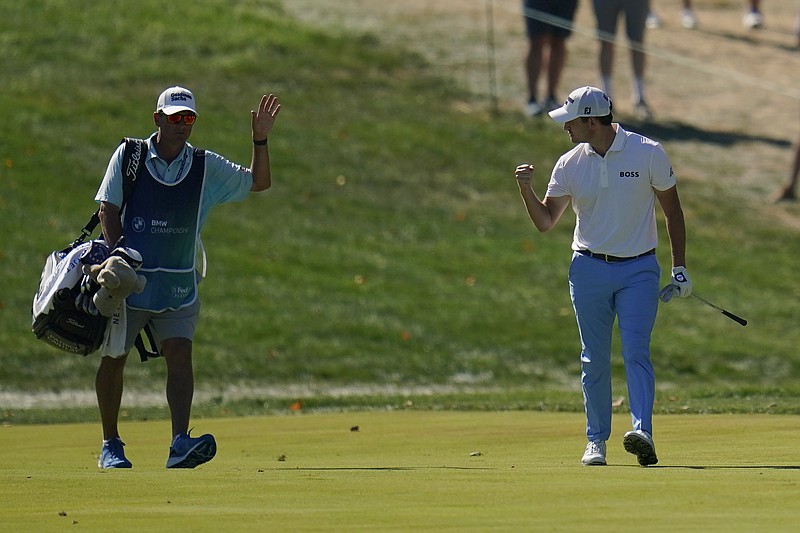 AP photo by Julio Cortez / Patrick Cantlay, right, celebrates with his caddie after he holed out from the fairway on No. 14 at Wilmington Country Club’s South Course on Saturday. Cantlay shot a 65 in the third round of the PGA Tour’s BMW Championship and took a one-shot lead into the final round.