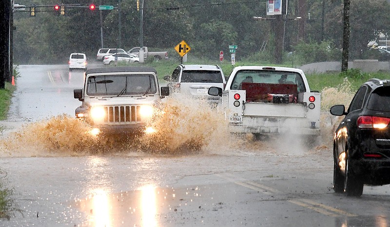 Staff Photo by Robin Rudd / Traffic splashes through muddy water on West 37th Street on August 10. The water was tinted brown by runoff from a nearby construction site. Heavy rains caused flash flooding and other disruptions in the Chattanooga area.