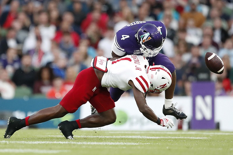 AP photo by Peter Morrison / Northwestern running back Cam Porter fumbles as he is tackled by Nebraska defensive back Marques Buford during the second half of Saturday’s game in Dublin, Ireland. Nebraska led 28-17 in the third quarter, but Northwestern rallied to win 31-28.