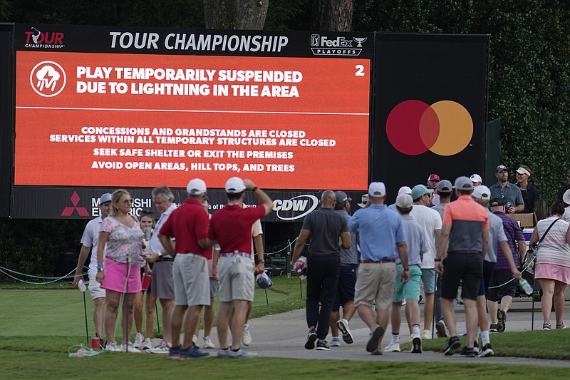 AP photo by Steve Helber / Spectators leave the course after play was suspended due to lightning in the area Saturday during the third round of the Tour Championship at East Lake Golf Club in Atlanta.