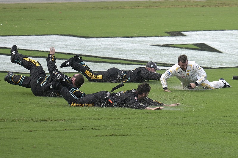 AP photo by Phelan M. Ebenhack / Richard Childress Racing driver Austin Dillon, right, celebrates by sliding on the infield grass with some of his crew members after winning Sunday’s NASCAR Cup Series race at Daytona International Speedway.