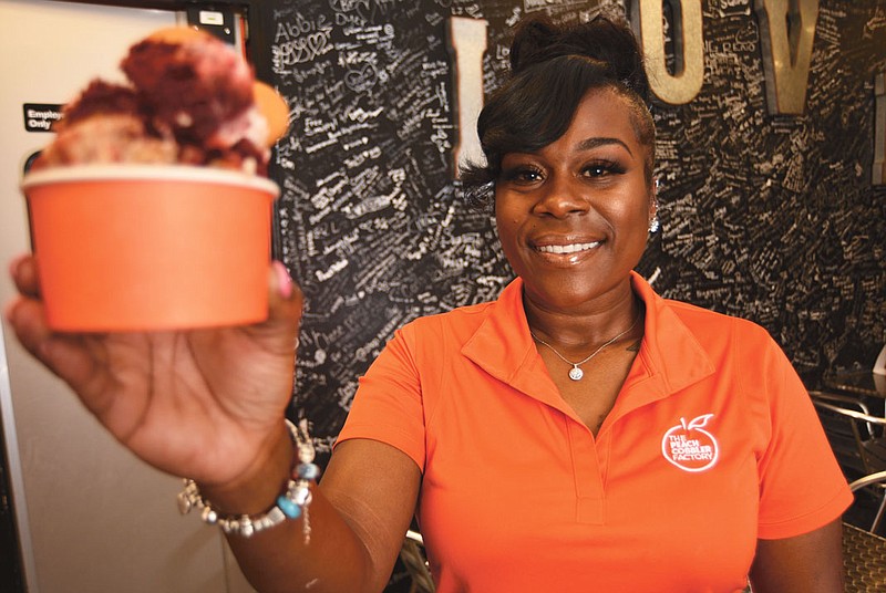 Photography by Matt Hamilton / Londie Nichole Price holds a cup of red velvet banana pudding at the Peach Cobbler Factory.