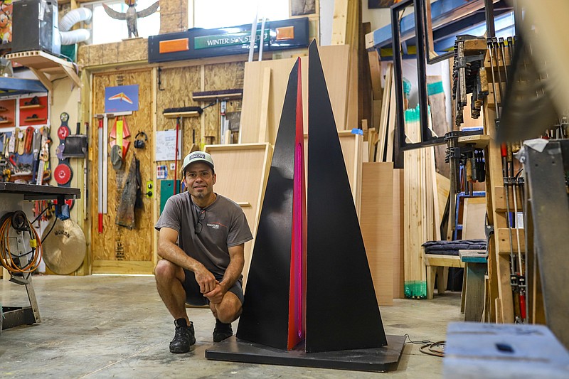 Staff photo by Olivia Ross / Andrew Nigh crouches beside the 5-foot replica that he will base his 40-foot-tall piece on for Fire Up the Fields at the Sculpture Fields at Montague Park on Oct. 22.