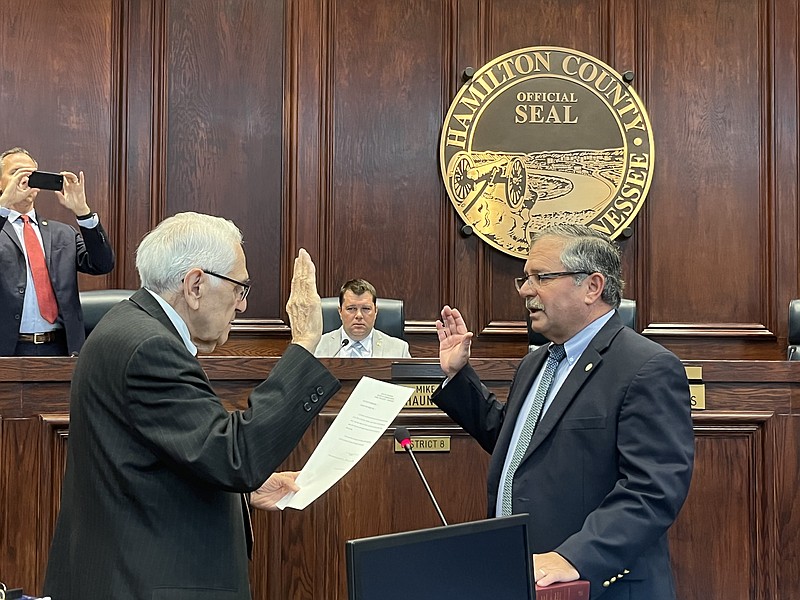 Staff Photo by David Floyd / Hamilton County Clerk Bill Knowles, left, swears in Commissioner Chip Baker, R-Signal Mountain, as chairman on Wednesday, Sept. 7, 2022.