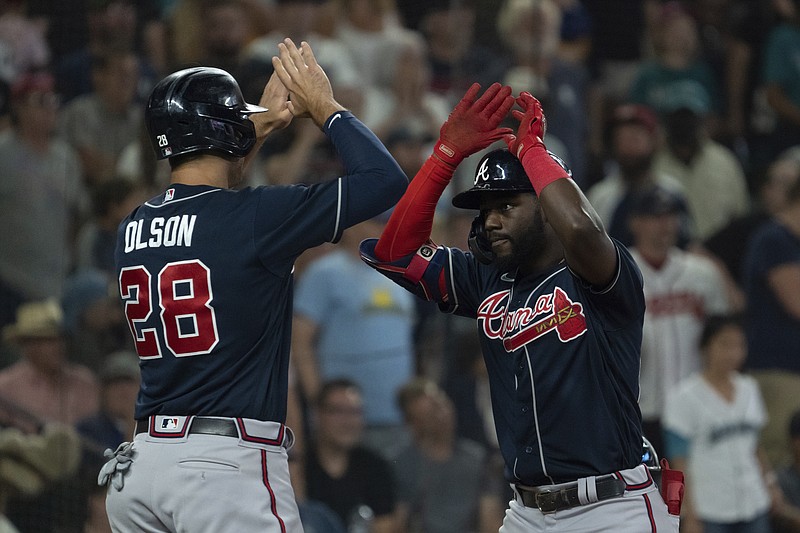 Atlanta Braves' Michael Harris II, right, is congratulated by Matt Olson after hitting a three-run home run off Seattle Mariners relief pitcher Diego Castillo during the ninth inning of a baseball game, Sunday, Sept. 11, 2022, in Seattle. (AP Photo/Stephen Brashear)