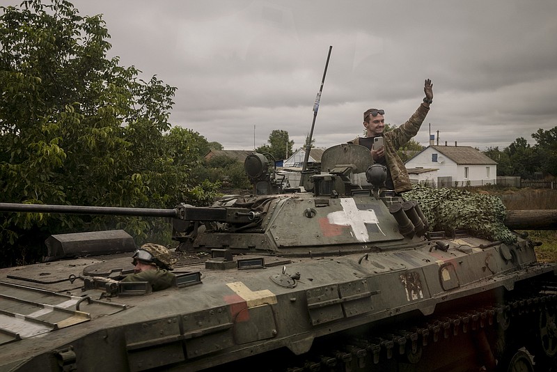 Nicole Tung/The New York Times / A Ukrainian soldier waves to passing buses near the recaptured village of Verbivka, Ukraine, on Sept. 13, 2022. “The staggering victory Ukrainian forces have achieved over Russia is Joe Biden’s victory, too,” writes New York Times columnist Bret Stephens.