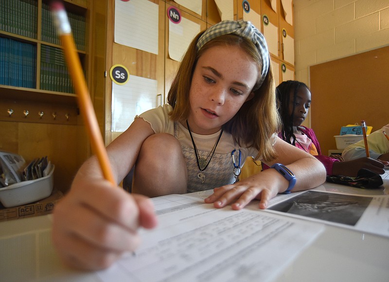 Staff photo by Matt Hamilton / Molly O'Donnell, 10, writes on a worksheet at Battle Academy on Tuesday, June 7, 2022.