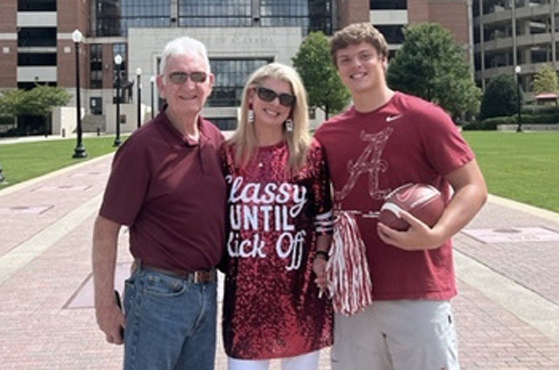 Homan family photograph via AP / Former Alabama split end Dennis Homan, left, poses with his daughter Missy Homan, center, and grandson Kneeland Hibbett, currently a long snapper for the Crimson Tide, outside Bryant-Denny Stadium in Tuscaloosa. Hibbett has pledged to donate a share of his NIL earnings to the Concussion Legacy Foundation.