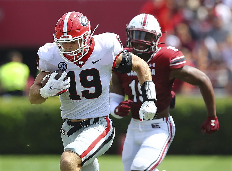 Atlanta Journal-Constitution photo by Curtis Compton via AP / Georgia tight end Brock Bowers catches a pass beyond South Carolina linebacker Brad Johnson and runs to the end zone during the third quarter of last Saturday's game in Columbia. It was Bowers' third touchdown of the game and covered 78 yards.