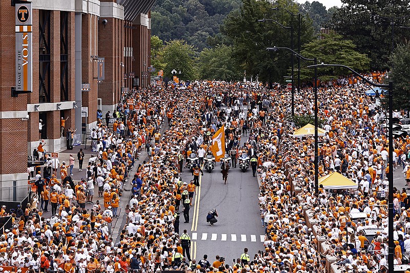 AP photo by Wade Payne / Tennessee football players and coaches make their way past fans outside Neyland Stadium during the Vol Walk before Saturday's SEC opener against Florida.