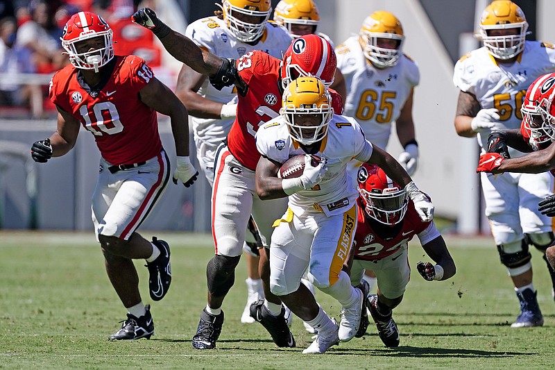 AP photo by John Bazemore / Kent State running back Marquez Cooper sprints away from Georgia defenders Robert Beal Jr. (33) and Malaki Starks (24) in the second half of Saturday's game in Athens, Ga.