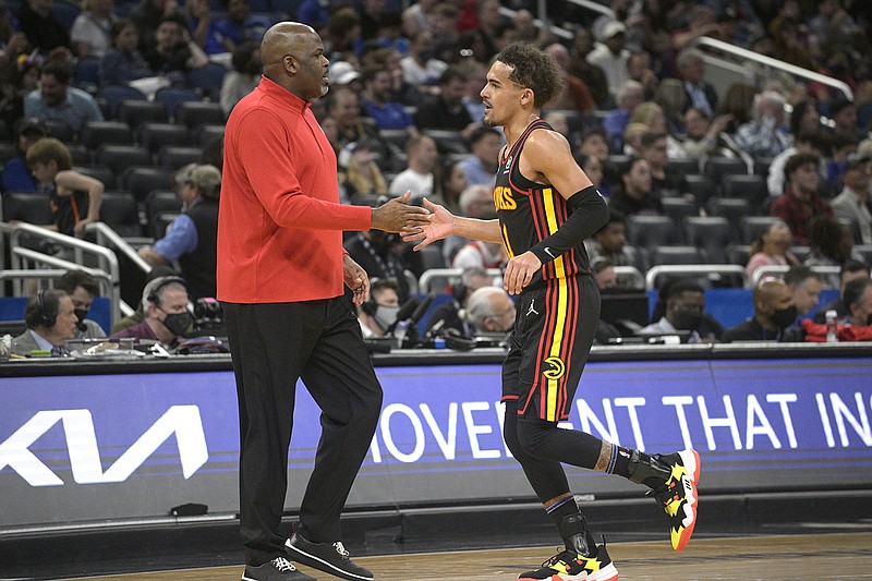 AP photo by Phelan M. Ebenhack / Atlanta Hawks coach Nate McMillan and point guard Trae Young slap hands during a road game against the Orlando Magic in February.