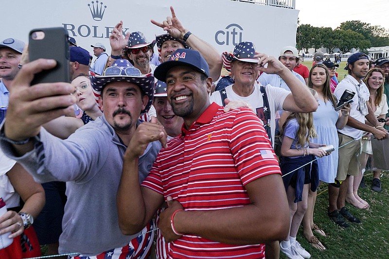 AP photo by Julio Cortez / Tony Finau poses for a photo with a fan after the United States defeated the International team to win the Presidents Cup on Sunday at Quail Hollow Club in Charlotte, N.C.