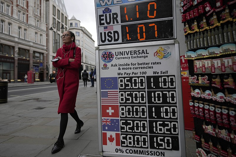 A woman walks past a sign that shows the exchange rate at a bureau de change in London, Tuesday, Sept. 27, 2022. The British pound has stabilized in Asian trading after plunging to a record low, as the Bank of England and the British government try to soothe markets nervous about a volatile U.K. economy. The instability is having real-world impacts, with several British mortgage lenders withdrawing deals amid concern that interest rates may soon rise sharply. (AP Photo/Frank Augstein)