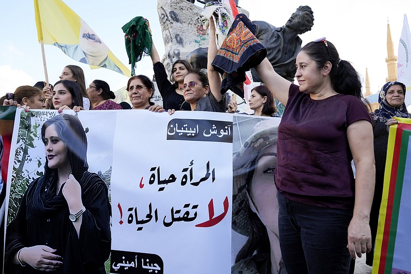 File photo by Bilal Hussein / The Associated Press / Kurdish women activists hold headscarfs and a portrait of Iranian woman Mahsa Amini, with Arabic that reads, "The woman is life, don't kill the life," during a protest against her death in Iran at Martyrs' Square in downtown Beirut on Sept. 21, 2022.