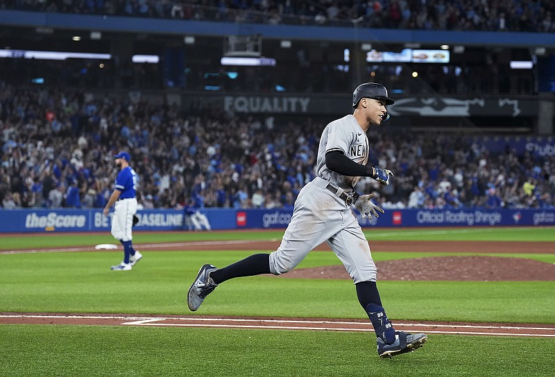 The Canadian Press photo by Nathan Denette via AP / New York Yankees designated hitter Aaron Judge runs the bases after hitting his 61st home run of the season, off Toronto Blue Jays reliever Tim Mayza, left, in the seventh inning of Wednesday night's game in Toronto.