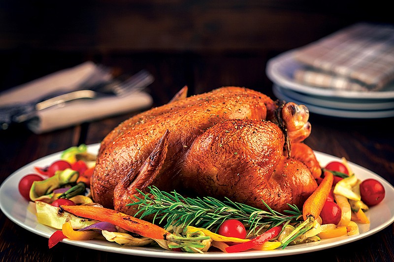 Roasted turkey served on plate with a variety of vegetables, ready for dinner on Thanksgiving. / Getty Images