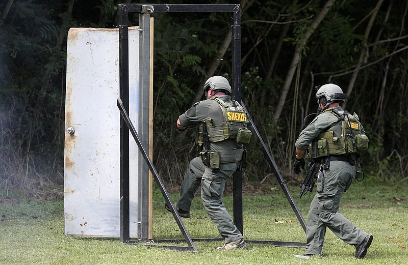 Staff File Photo / Members of the Hamilton County Sheriff's Office SWAT team breach a door during a 2017 media day of demonstrations of what they do at the current law enforcement firing range on Moccasin Bend.