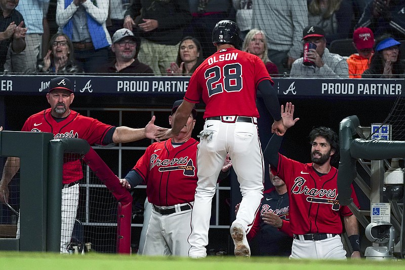 AP photo by John Bazemore / Atlanta Braves first baseman Matt Olson is greeted at the dugout entrance by, from left, bench coach Walt Weiss, manager Brian Snitker and shortstop Dansby Swanson after scoring on an Eddie Rosario sacrifice fly during the seventh inning of Friday night's home win against the New York Mets.