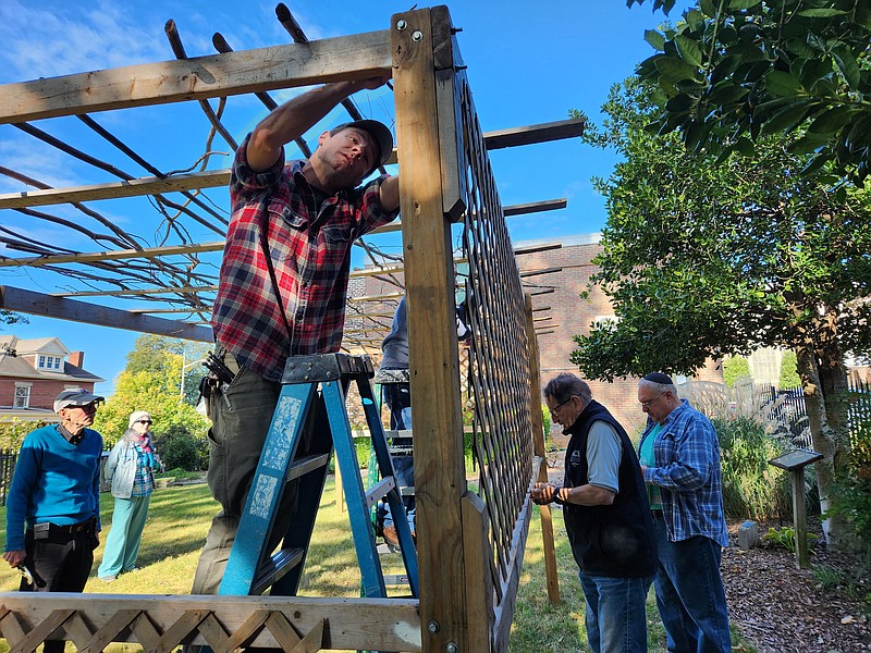 Staff Photo by Andrew Schwartz / Volunteers from the Mizpah and B'Nai Zion congregations construct a Sukkah on Sunday. Mizpah congregation member Chris Conn works in the foreground.