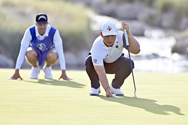 AP photo by David Becker / As his caddie looks on, Tom Kim lines up his putt on the 17th green at TPC Summerlin during Sunday's final round of the Shriners Children's Open in Las Vegas. Kim, 20, became the first player since Tiger Woods in 1996 to win twice on the PGA Tour before turning 21.